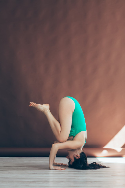 年轻女子做瑜伽体式支撑头倒立