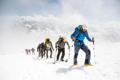 一群登山运动员爬上了一座白雪皑皑的山峰