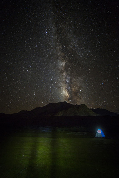 银河之星在被照亮的帐篷上闪耀