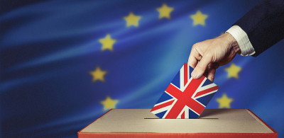 Brexit投票的概念。无法辨认的投票人的手将选票放入投票箱，并留有文字栏位