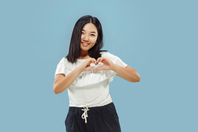 蓝色背景上的韩国年轻女子的半长肖像