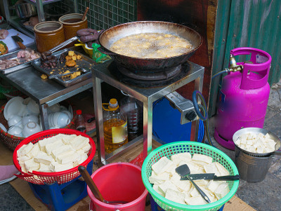 油炸豆腐在大锅或炒锅里装满油。越南街头小吃摊，垃圾食品不健康。