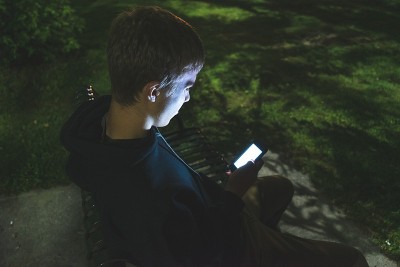 一个青少年在晚上打手机。