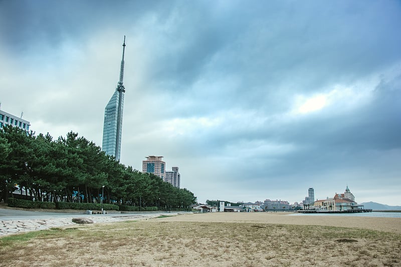 风暴即将登陆日本九州福冈湾的海滩。多云的日子里，海滨桃口、博多市中心CBD和福冈塔的城市景观