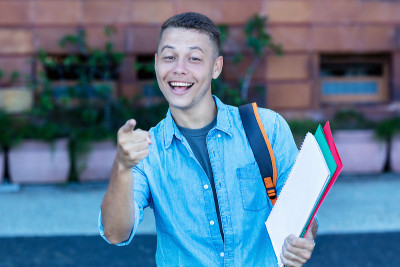 快乐的金发男学生走向大学