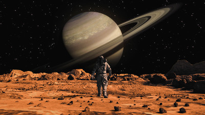 勇敢的宇航员穿着宇航服自信地行走在火星上，前往布满岩石的外星红色星球土星。第一位登上火星的宇航员。先