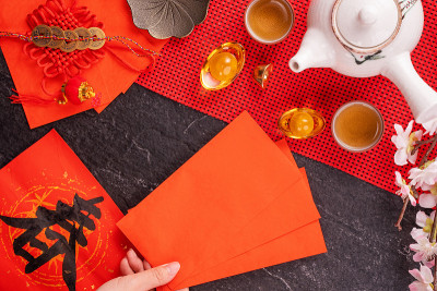 中国农历一月新年的设计理念——女人拿着，给红包(ang pow，红包)作为压岁钱，俯视图，平躺，头顶