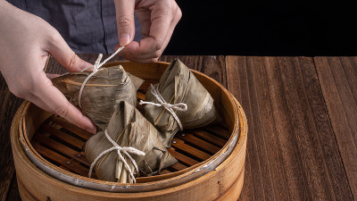汤圆、粽子——端午节，黑色背景的木桌上蒸着一串中国传统食物。