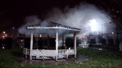 晚上在公园里燃烧山茶花。烟从屋顶冒出来。