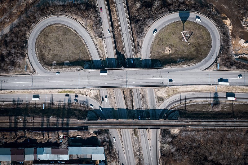 道路车辆在十字路口或十字路口或交通枢纽作圆周运动，鸟瞰俯视图