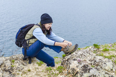 女孩把鞋带系在登山靴上
