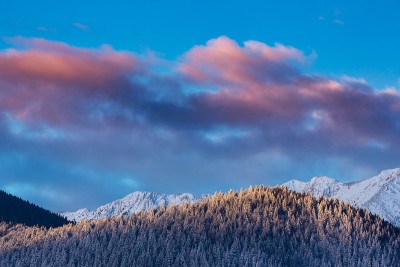 冬天的风景在山上，有白雪覆盖的山峰和落日的月亮