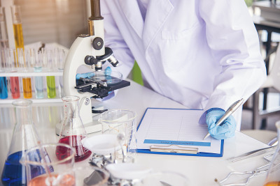 特写女科学家手用滴管在实验室看科学显微镜医学试验，研究生物化学。女性技术员实验室分析血液科学药物研究