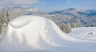 雪道旁边的雪堆，以山为背景