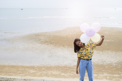 亚洲年轻女孩喜欢在海滩上玩气球。