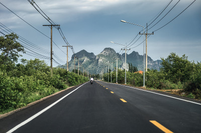 山姆罗伊约乡村高速公路上的电线杆和灯柱，可以看到绿色的山脉
