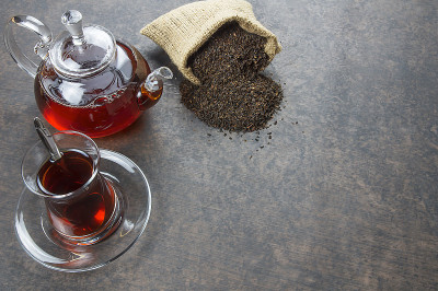 玻璃土耳其红茶和玻璃茶壶干红茶和干茶叶在黑色的乡村桌子上