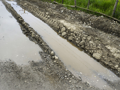 雨后肮脏的乡村土路上有深深的轮胎印