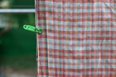 塑料衣夹、绿针和印花布在晾衣绳上晾干