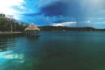 木旧码头在日落与巨大的雨云伊察湖，El Remate, Peten，危地马拉