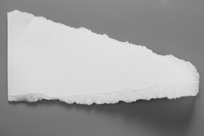 白色的撕破的纸在灰色的背景上。收集纸撕开