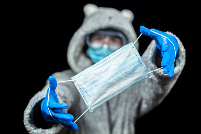 医学的面具。一个穿着泳衣的女人拿着医用口罩。