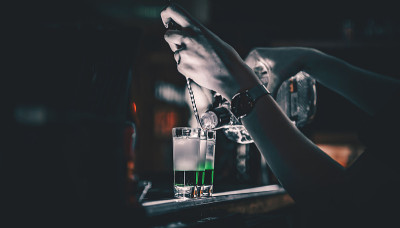 调酒师收集多彩的酒。吧台的一套鸡尾酒