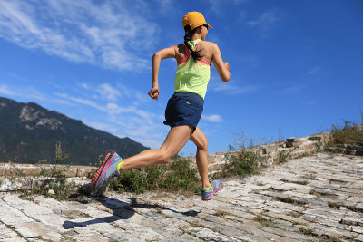 年轻的健身女子越野跑运动员在长城山顶上跑步