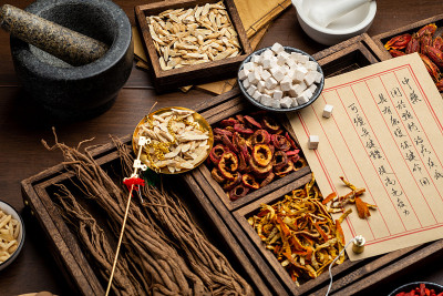 桌上放着古老的中医书籍和药草