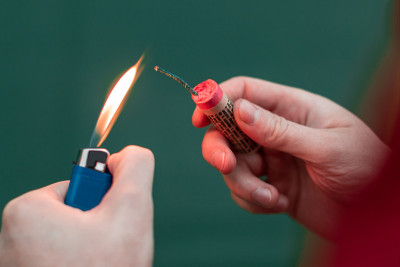 男人在他的手中点燃爆竹