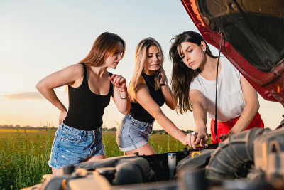 女孩们在高速公路上检查坏掉的汽车