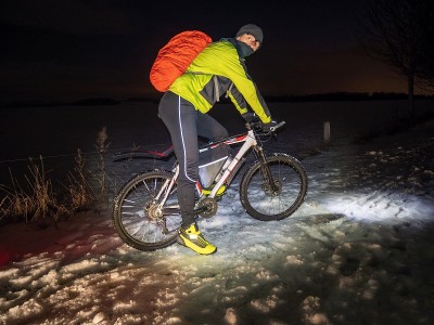 在雪夜独自骑山地车。冰冷的道路