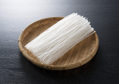 黑色背景上的漏勺里的面条
