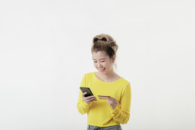 年轻女子用电话和信用卡在网上购物