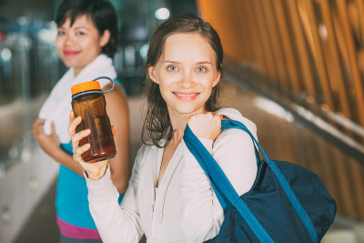 友好的运动女人与水和女性朋友