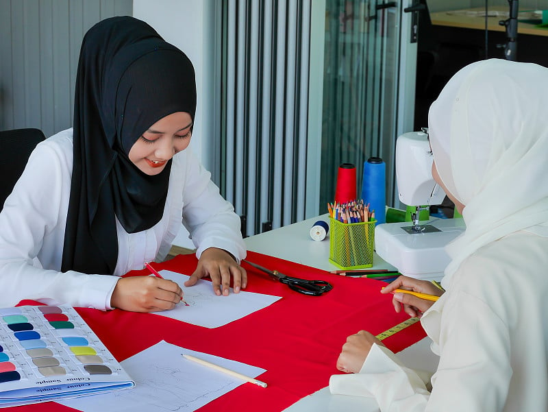 女穆斯林时装设计师戴着HIJAB在工作室的服装设计师项目工作在家工作