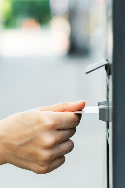 女性手拿信用卡和自动售票机