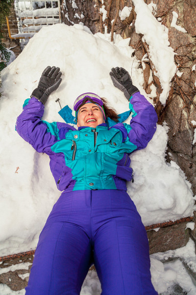 穿着运动服的女孩躺在雪地上