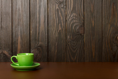 陶瓷杯的咖啡和茶的绿色在黑暗的木制背景。