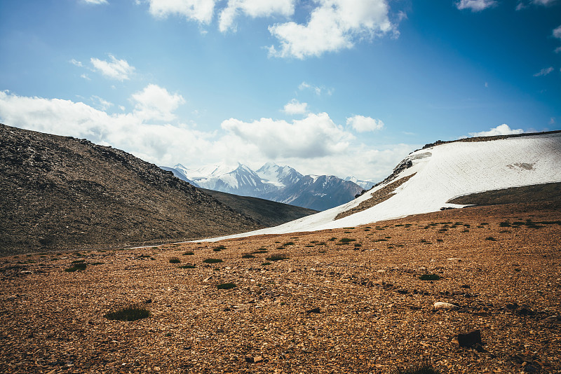 风景优美的高地景观与冰川小山背景大雪山山顶在低云。从高山上的沙漠到雪山在低云层中的壮观景色。