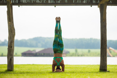 shirshasana。瑜伽女孩训练户外自然背景。瑜伽的概念。