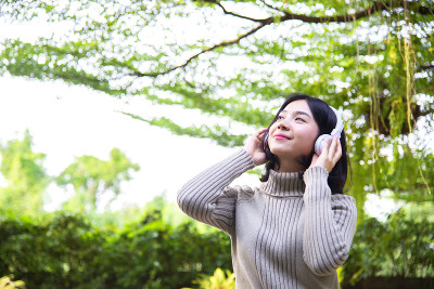 女性自由生活，在清晨的花园中聆听自然的音乐和放松，放松和平静