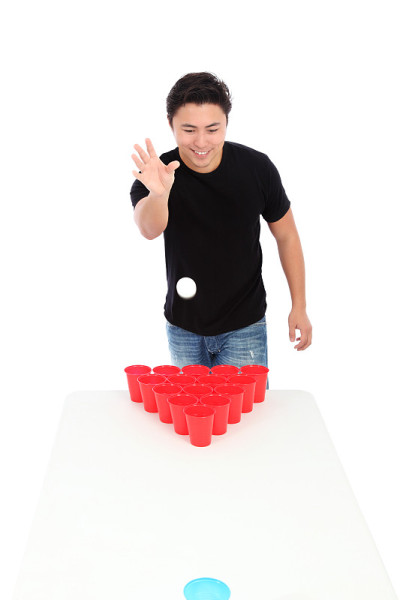 一个年轻人在玩啤酒乒乓的孤立画面