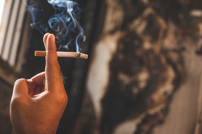 近男手里拿着一根香烟。