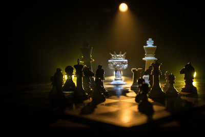 棋牌游戏的经营理念和竞争理念以及战略理念。象棋人物在黑暗的背景与烟和雾和窗户与阳光。有选择性的重点