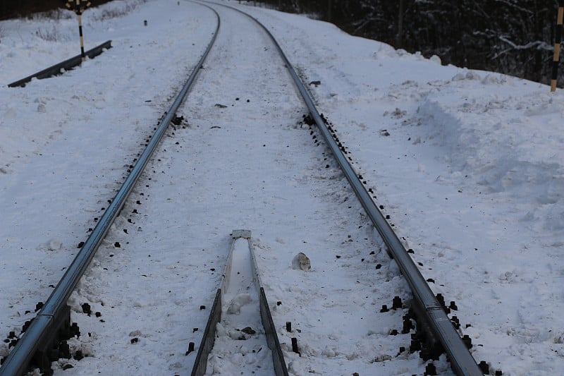 铁路在冬天。铁轨和枕木——覆盖着积雪的机车和电力机车的道路。