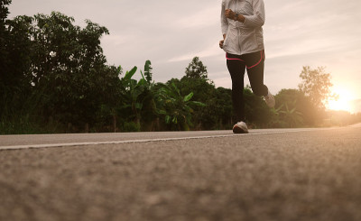 女性跑步者在公路跑道上跑步，进行马拉松和健身训练。健康的生活方式的概念。运动员在户外跑步锻炼。特写的