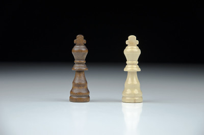 在模糊的黑白背景与反射上的两个象棋王的近景