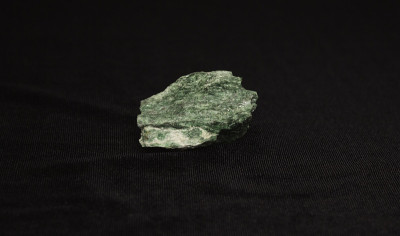 樱红色矿物云母。石头在黑色背景上是绿色的。