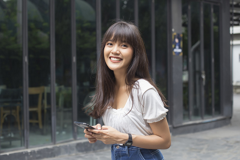 快乐的亚洲女人拿着智能手机